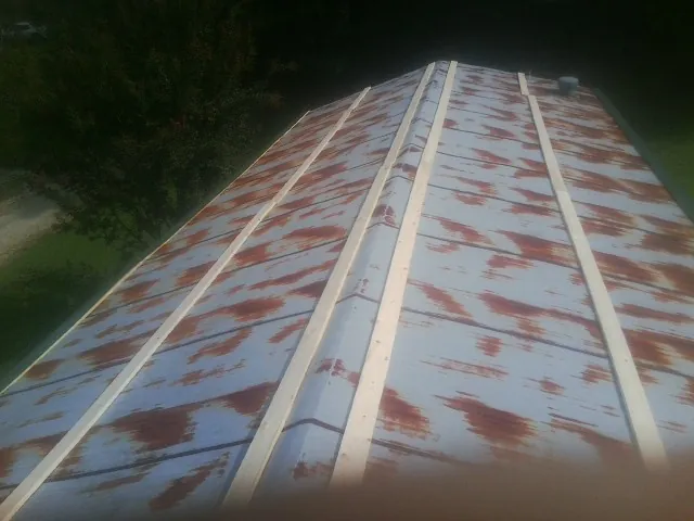 Rusted metal roof panels with new wood purlins before replacement — Storm Damage Roof Repair in Geuda Springs by Roofing Brothers
