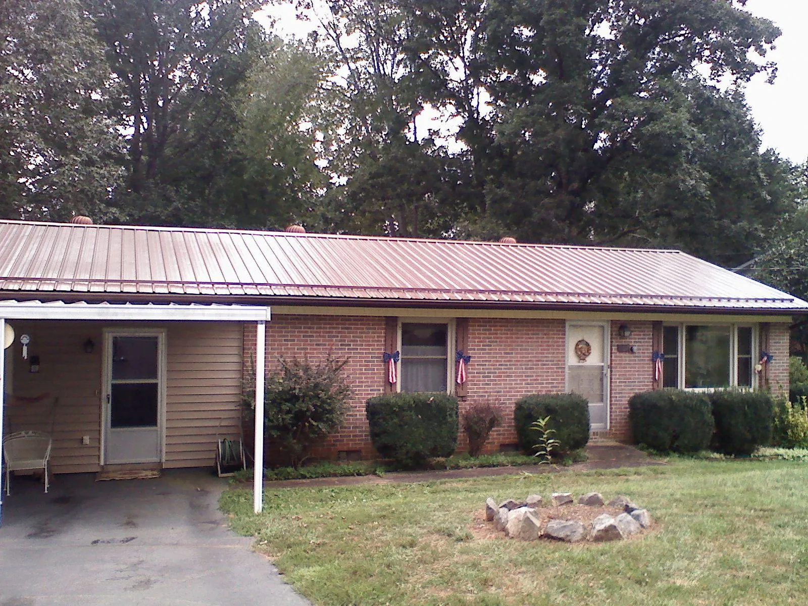 Bronze metal roof and carport on a brick ranch home — Roof Repair work by our crew in Geuda Springs