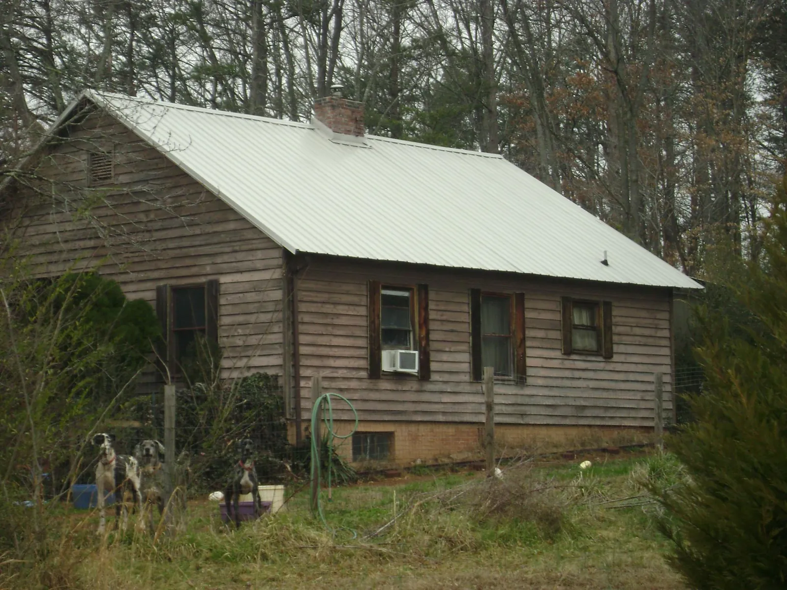 White metal roof on an old wood sided farmhouse, from a Asphalt Shingle Roof Repair job in Geuda Springs